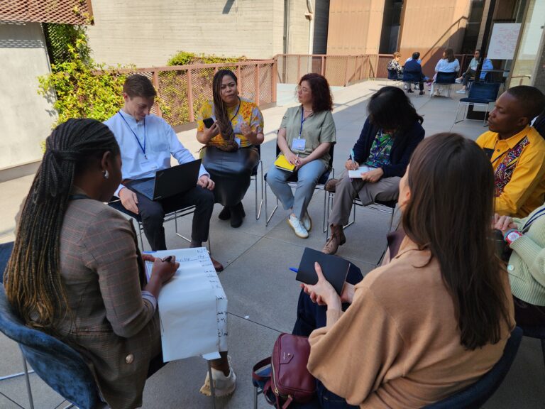 Group of people sitting in a circle and learning during a training course